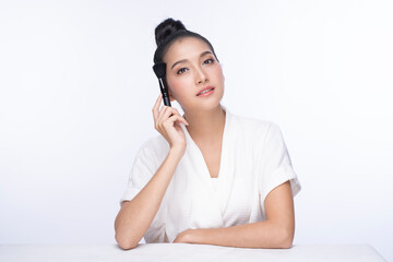 Portrait of woman applying dry cosmetic foundation on the face using makeup brush. Girl without makeup with clean skin with a makeup brush in hand. Cute woman face with fresh clean flawless skin.