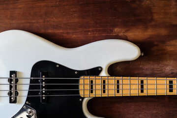 Obraz na płótnie Canvas white electric bass guitar on wood background with copy space