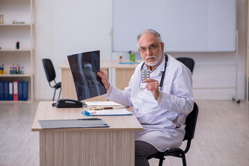 Old male doctor radiologist working in the clinic