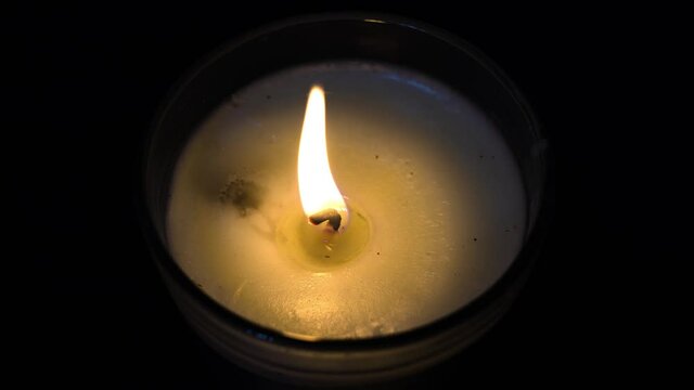 Close up on candle light on black background. Over look. Imagery is about prayer, holiday, warmth, and life.