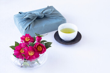 風呂敷包みと美しい山茶花とお茶