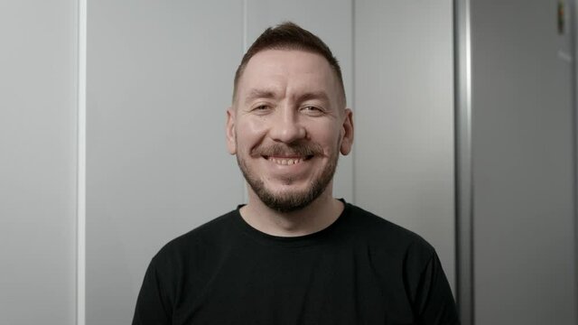Portrait of a young man. The guy looks at the camera and smiles affably.