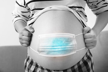 Photo A pregnant woman took a mask off her black-and-white belly, a concept protecting the epidemic. Prophylactic diseases cowd 19