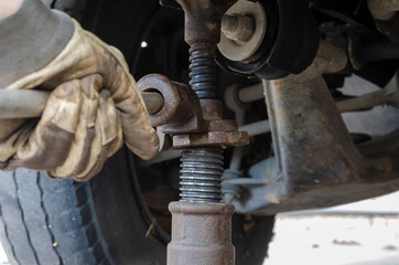 Tire service, car service concept. Hand in glove lifts the car with a mechanical jack.