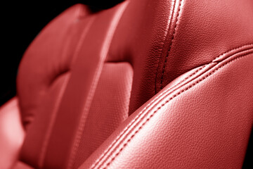 Modern luxury car red leather interior. Part of red leather car seat details with stitching. Interior of prestige car. Comfortable perforated leather seats. Perforated leather.