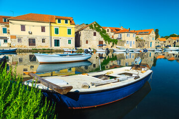 Fototapeta na wymiar Vrboska mediterranean village with stone houses and moored boats, Croatia