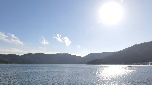 Lake Yogo in Shiga Prefecture in winter, the surface of the pond illuminated by the strong sunlight.