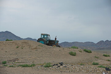 Almaty, Kazakhstan - 06.25.2013 : Old tractor on the slope of a sandy hill in the Altyn Emel Nature Reserve