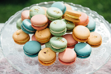 Macarons in various colors on glass plate