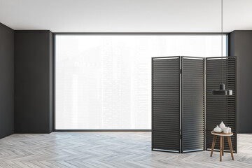 Grey hall with black wooden screen and small table, large window
