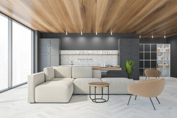 Living room with sofa, armchair and grey kitchen set near window