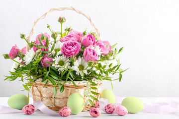 Easter background, paited eggs and basket of flowers on white. Happy Easter. Copy space.