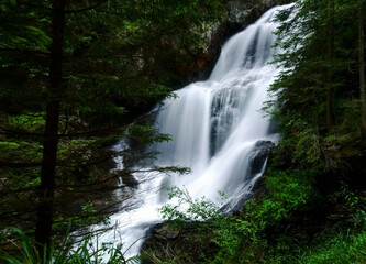 large soft flowing waterfall in the green forest