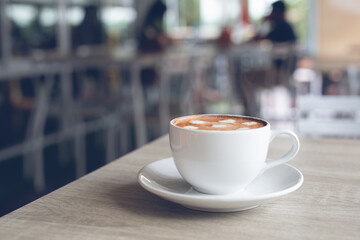Cup of white porcelain coffee on table in coffee shop