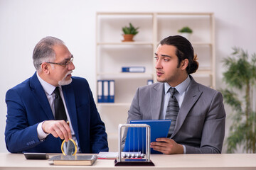 Two businessmen and meditation balls on the table