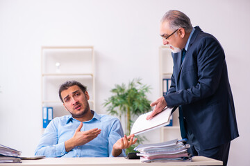 Obraz premium Old boss and his young assistant in the office