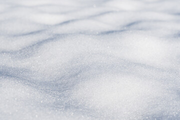 Close up of snow covered ground with uneven surface and shadows seen from the side at low angle