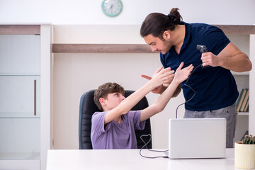 Young father and schoolboy playing computer games at home