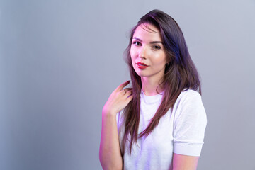 Business woman standing on neon studio background. Beautiful female  portrait.