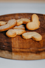 Heart-shaped cookies on round wooden cutting board. Saint Valentine's cookies in shape of heart on white background.