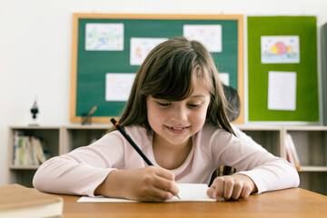 Asian elementary school kids studying in a classroom. The girl smiled