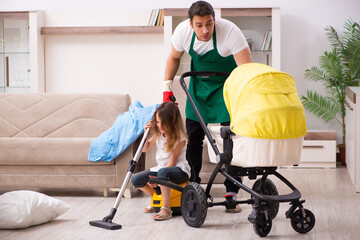Young male contractor cleaning the house with his small daughter