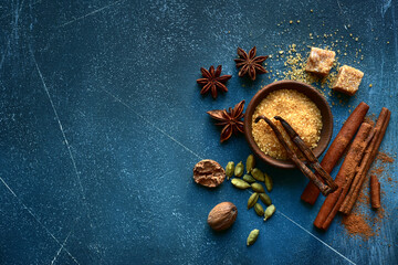 Fototapeta na wymiar Set of winter spices : cinnamon, anise, cardamon, nutmeg, clove, vanilla and brown sugar .Top view with copy space.