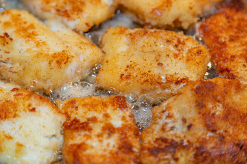 Breaded tender cod fillet pieces are fried in a pan