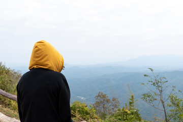 Women in hoodies stand back to enjoy the mountain view in the morning.