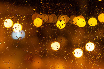 Glass with water drops with an unfocused urban background by night
