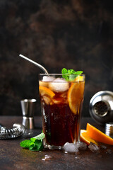 Cold summer soda cocktail with cola, dark rum and orange.