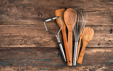 A set of cooking accessories on a wooden background. Top view with space to copy. Concept of culinary backgrounds.