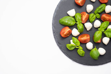 on a stone stand mozzarella, fresh basil and tomatoes