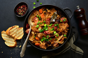 Bigos - traditional dish of polish cuisine,stewed cabbage with meat, sausage and dried mushrooms. Top view with copy space.