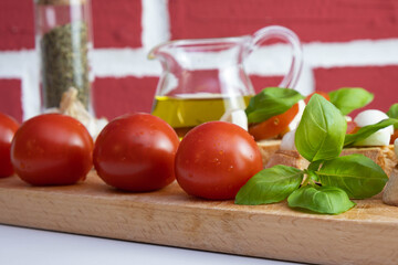 on a wooden stand are crackers with small mozzarella, basil and tomatoes