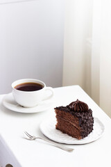 Chocolate cake and coffee, still life in a light interior.