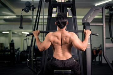 Fototapeta na wymiar Bodybuilder man with big muscular back in the gym