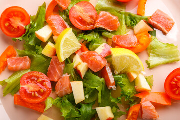 Salad with salmon and cherry tomatoes and lemon close-up.