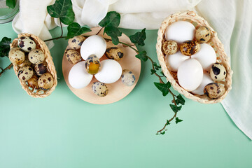 Flat lay easter composition with green leaves and easter eggs on a yellow background