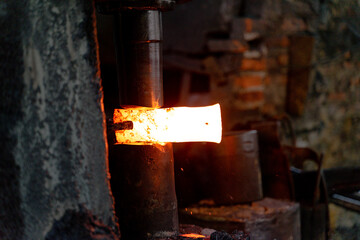 The blacksmith is forging very hot iron to make various tools.
