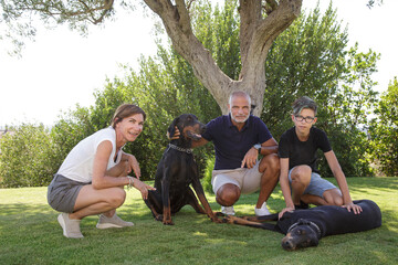 Bella famiglia con i cani, sorride felice nel prato del giardino di casa