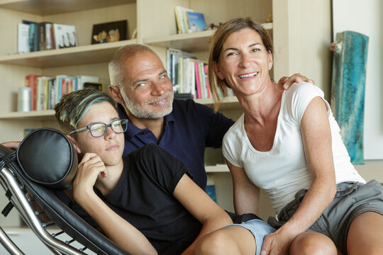 Famiglia felice si abbraccia nel divano di casa