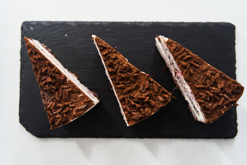 a slice of chocolate chip cake on a black tray. High quality photo