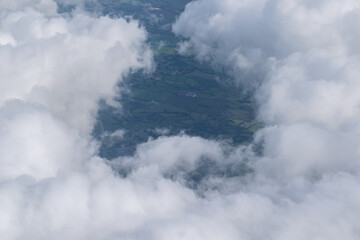 Clouds view from the sky with visible part of land below