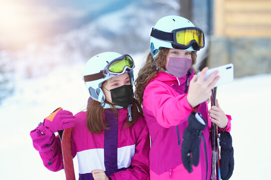 teenagers friends taking selfie in covid masks on the ski slope