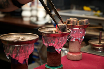 A closeup shot of barista preparing hookah in the bar