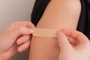 The man seals the wound with adhesive plaster. Vaccine. Wound. The medicine. Place for an inscription. Advertising.. Vaccine. Wound. The medicine. Place for an inscription. Advertising.