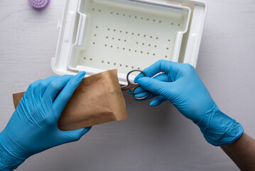 Close-up of manicurist hand is taking manicure tool from craft envelope in manicure salon.