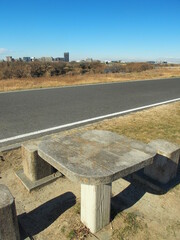 冬のサイクリング道路のある江戸川土手と冬枯れの河川敷風景
