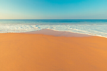 Fototapeta na wymiar Beautiful scenery of morning sandy beach and turquoise ocean foamy waves at Sri-Lanka.
